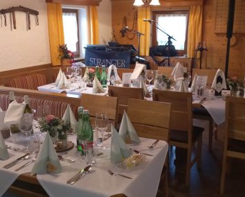 Festlich eingedeckte Tische im Berggasthof Pilzegg mit Blumen und Gläsern.