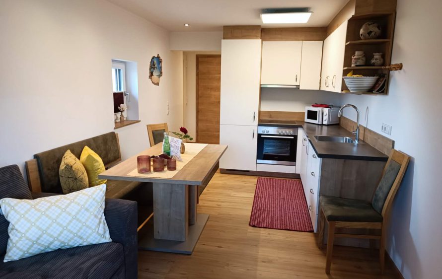 Moderne Ferienwohnung im Berggasthof Pilzegg mit Küche und gemütlicher Sitzecke.
